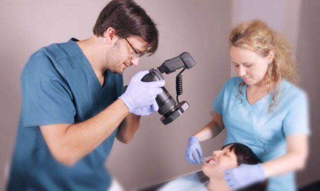 Dr. Steinhof Péter Márton egy páciense fogainak fotózása közben