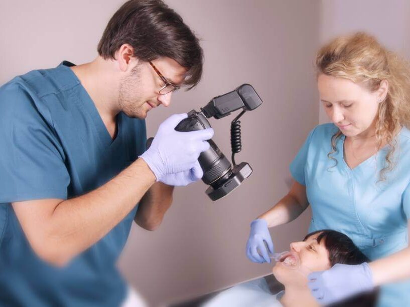 Dr. Steinhof Péter Márton egy páciense fogainak fotózása közben