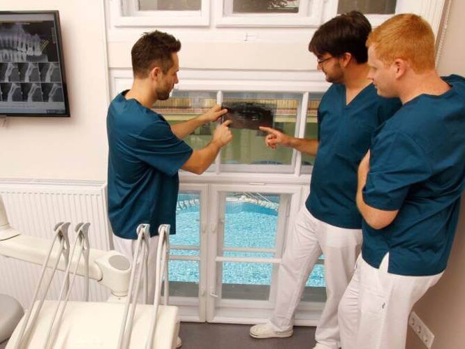 A képen fogspecialistáink egyik páciensünk panoráma röntgenképét elemzik a megfelelő beavatkozás kiválasztása érdekében.